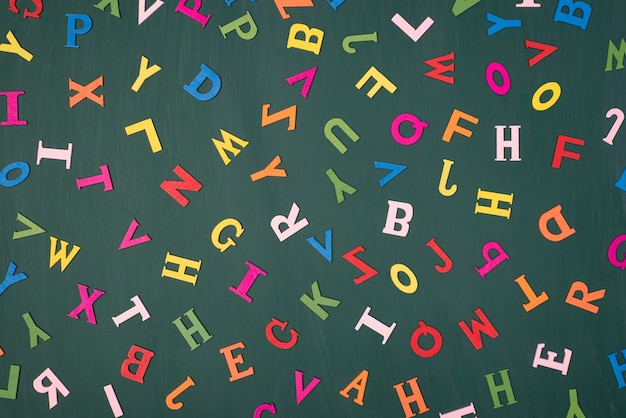 Litery tło studia koncepcja języka englidh. Widok z góry na zdjęcie kolorowych liter na zielonej tablicy