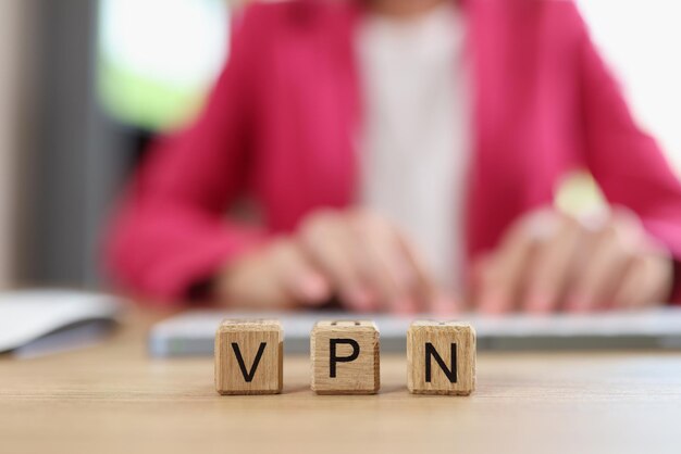 Litery VPN na drewnianych kostkach Wirtualna sieć prywatna i użytkownik Internetu pracuje na komputerze w tle