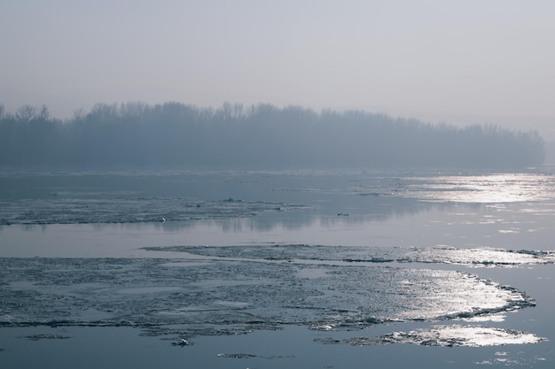 Lód unosi się w rzece. Przełamywanie lodu. Odbicie słońca. Duży kawałek lodu w rzece. topnienie lodu