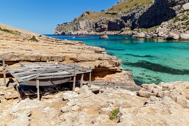 Łódka spoczywa pod drewnianą szopą w pobliżu malowniczej plaży, Szopa na łódkę