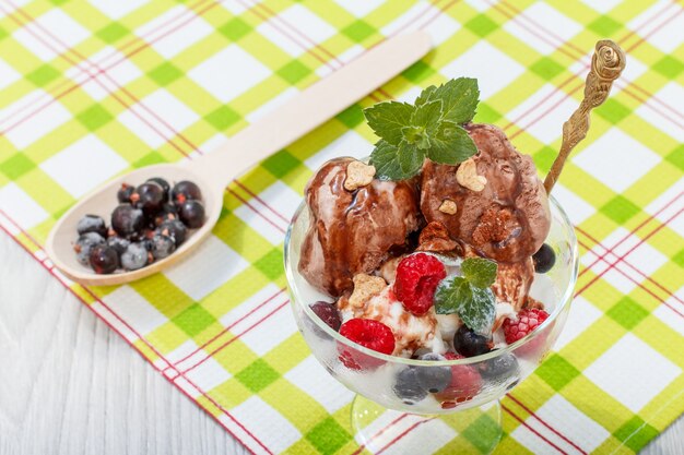 Lody czekoladowo-białe z jagodami malinowo-porzeczkowymi i listkami mięty w szklance