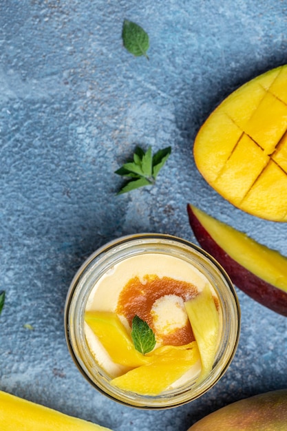 Lody mango ze świeżymi owocami mango podawane w szklanym słoiku włoskie lody deserowe