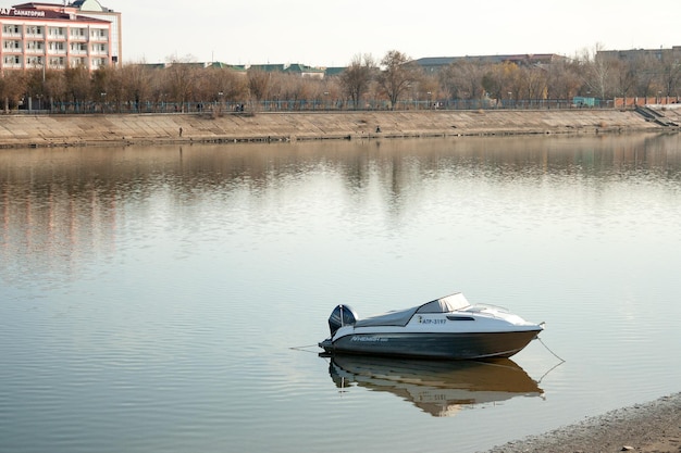 Łódź jest zacumowana do brzegu rzeki na skarpie miejskiej