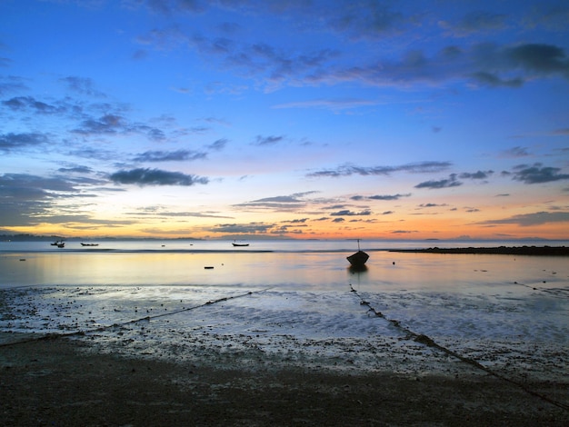 Łódź rybacka w morzu przy wschodem słońca