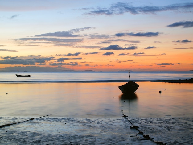 Łódź rybacka w morzu przy wschodem słońca