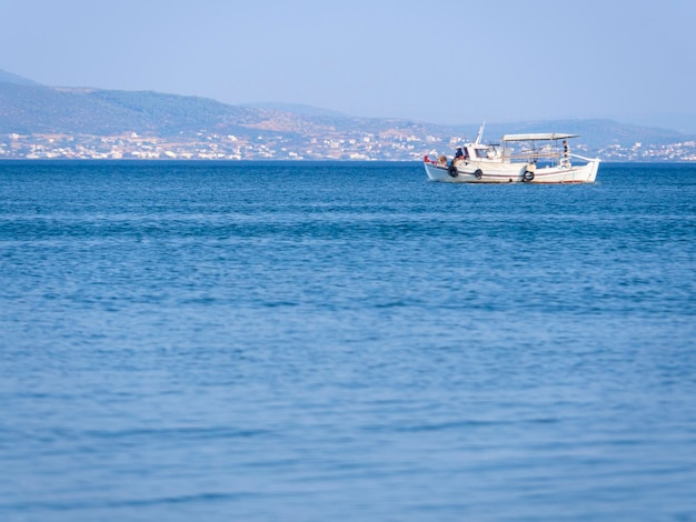 Łódź rybacka w słoneczne popołudnie na spokojnym Morzu Egejskim na wyspie Evia w Grecji