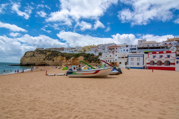 Łodzie na plaży w miejscowości Carvoeiro z kolorowymi domami Algarve