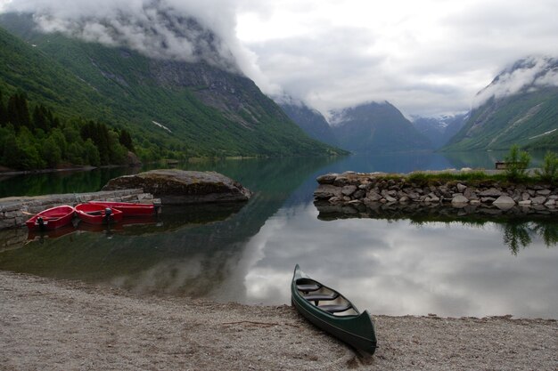 Łodzie na plaży z górami i pochmurnym niebem w tle, norwegia