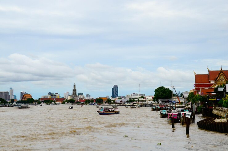 Zdjęcie łodzie na rzece chao phraya na chmurowym niebie