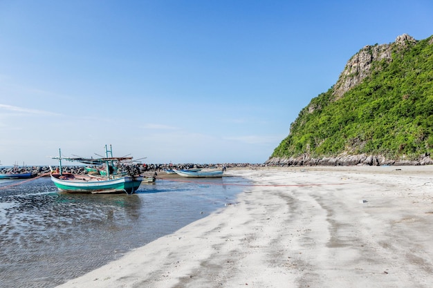 Zdjęcie Łodzie zacumowane na plaży na tle jasnego niebieskiego nieba