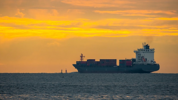 Logistyka import eksport kontenerowiec Statek towarowy w porcie morskim na zachodzie słońca, transport towarowy statkiem kontenerowym