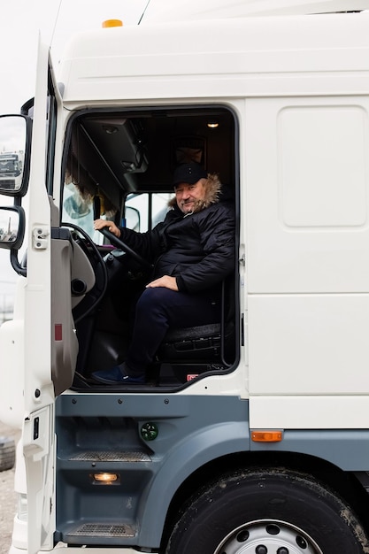 Zdjęcie logistyka kierowcy lub spedytora pod osłoną ciężarówki i kierowcy naczepy w punkcie przeładunkowym