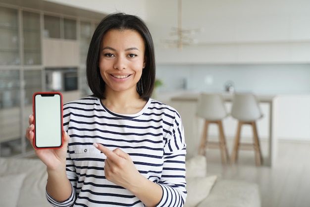 Lokatorka Wskazująca Na Telefon Z Makietą Pustego Ekranu Poleca Aplikację Usługi Wynajmu W Domu