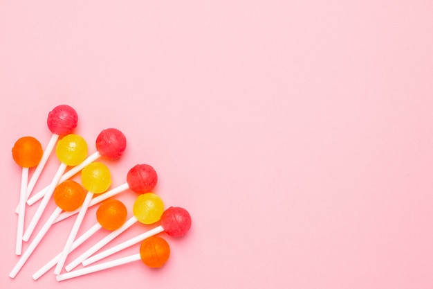 Lollipop W Pastelowym Różu Ze Słodkimi Różowymi, Pomarańczowymi I żółtymi Cukierkami. Minimalistyczna Kompozycja.