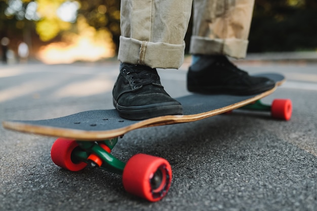 Longboard z czerwonymi kołami na asfalcie. Wysokiej jakości zdjęcie