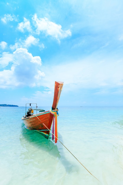 Longtale łódź na białej plaży przy Phuket, Tajlandia.