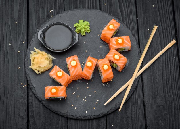 Łososiowe sushi rolki na czerni.