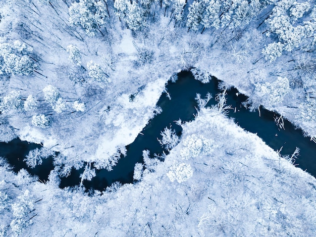 Lot nad lasem ze śniegiem i płynącą rzeką w polsce