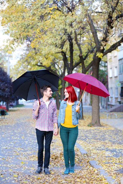 Loving para pod parasolem w jesiennym parku