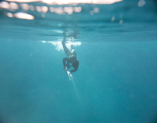 Łowiący podwodne mężczyzna z latarką na szczycie jeziora Podwodny strzał
