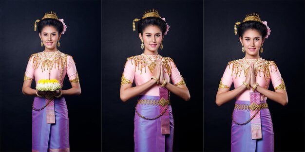 Loykrathong sukienka z tajskiego tradycyjnego stroju lub z Azji Południowo-Wschodniej złota sukienka w azjatyckiej kobiecie ze stojakiem na dekoracje wyrażają uczucie szczęśliwego uśmiechu dla Loy Krathong Pływający festiwal na czarnym tle