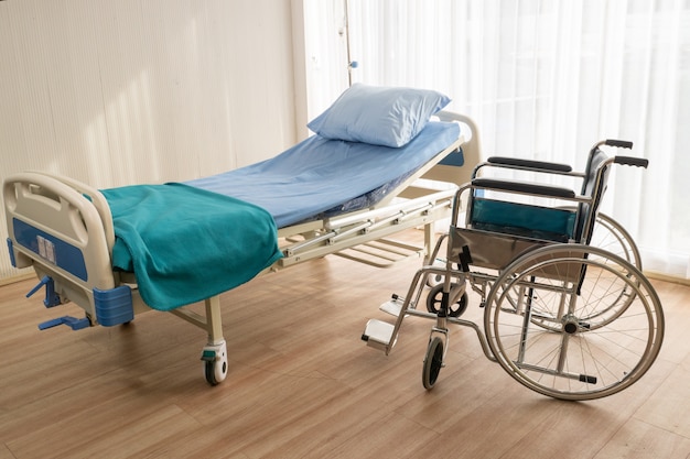 Łóżko szpitalne i wózek inwalidzki w sali szpitalnej