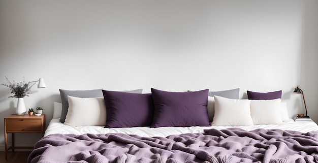 Łóżko z fioletowymi poduszkami i białą ścianą za nim.