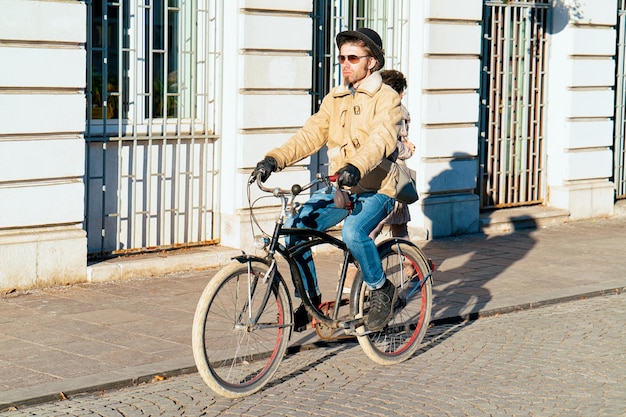 Lublana, Słowenia - 15 Stycznia 2019: Hipster Mężczyzna Jeżdżący Na Rowerze Po Ulicy I Pejzażu Miejskiego Starego Miasta W Lublanie W Słowenii. Ludzie Na Rowerze I Cyklu W Słoweńskim Mieście Widok Zimą. Rowerzysta I Droga