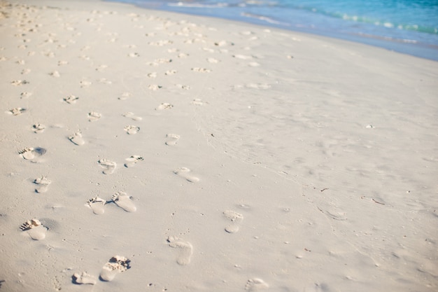 Ludzcy odciski stopy na białej piasek plaży