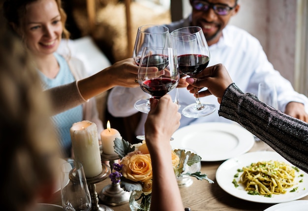 Ludzie Clinging Wine Glasses Together w restauracji