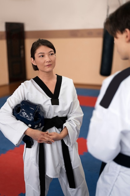 Zdjęcie ludzie ćwiczący taekwondo w sali gimnastycznej