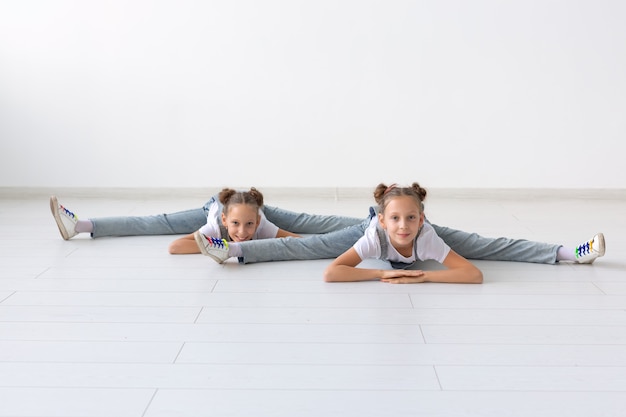 ludzie, dzieci i koncepcja akrobatyczne - małe bliźniaczki ćwiczenia na białym tle