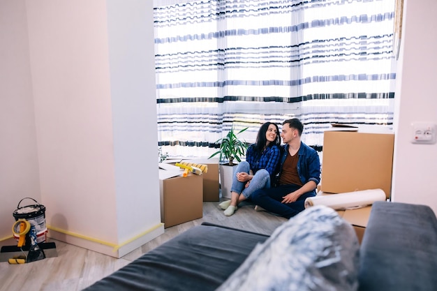 Ludzie hipoteczni i koncepcja nieruchomości szczęśliwa para z pudełkami przenosząca się do nowego domu