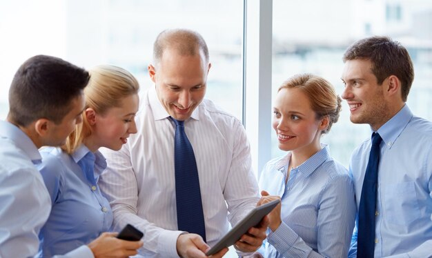 Zdjęcie ludzie i koncepcja korporacyjna zespół biznesowy z komputerem tabletem w biurze