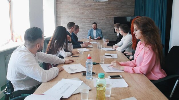 Ludzie na konferencji biznesowej Szef coś wyjaśnia, a koledzy na niego patrzą