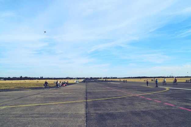 Zdjęcie ludzie na pasie startowym lotniska na tle nieba