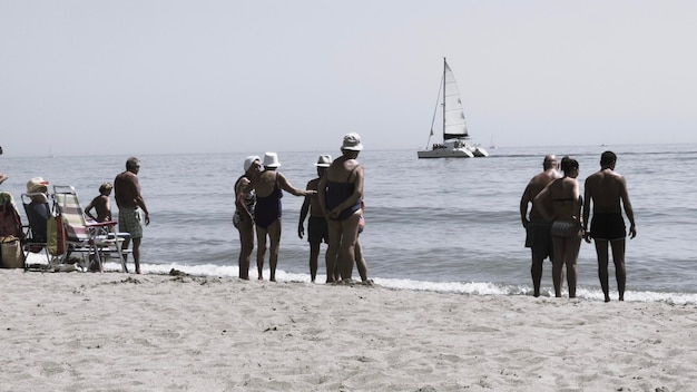 Zdjęcie ludzie na plaży na czystym niebie