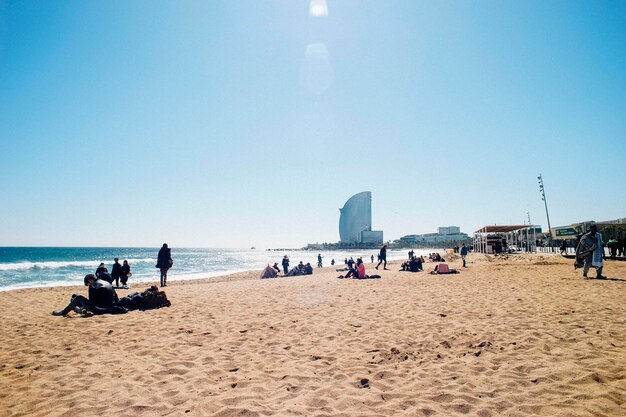 Zdjęcie ludzie na plaży na tle czystego nieba