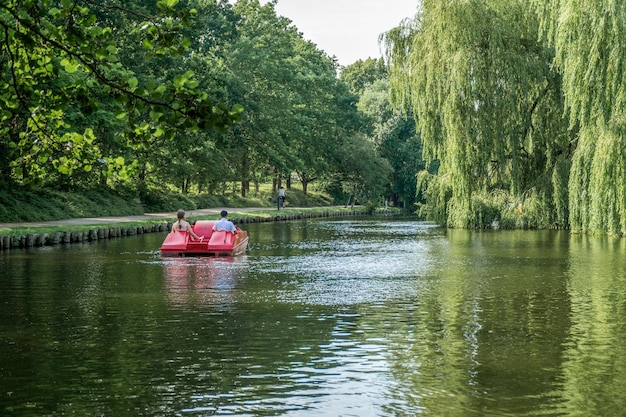 Ludzie na rowerze wodnym płynący po rzece w Munke Mose Park Odense Dania