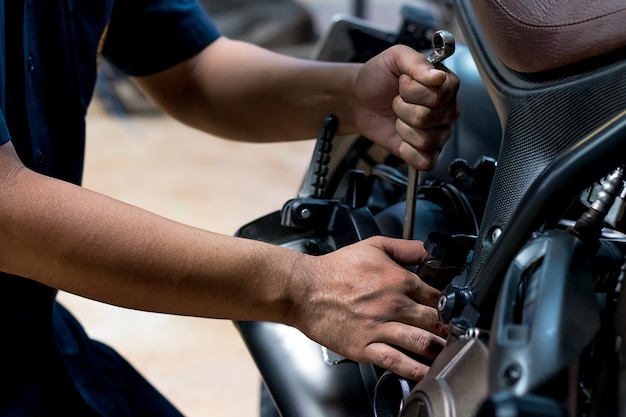 Ludzie naprawiają motocykl Użyj klucza i śrubokręta do pracy.