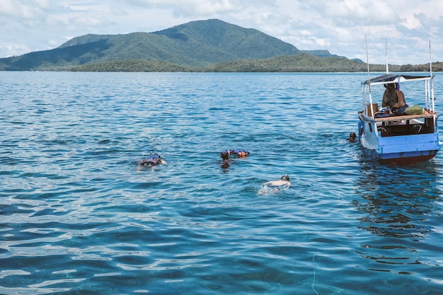 Ludzie Pływający I Nurkujący W Morzu Z Pływającą Tradycyjną łodzią W Karimun Jawa