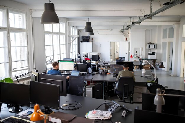 Zdjęcie ludzie pracujący przy komputerach w otwartym biurze