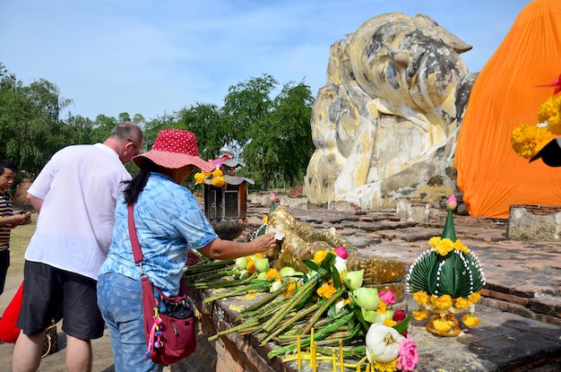 Ludzie przychodzą do świątyni Wat Lokayasutharam, aby podróżować i modlić się do Leżącego Buddy 10 stycznia 2016 r. w Ayutthaya Tajlandia