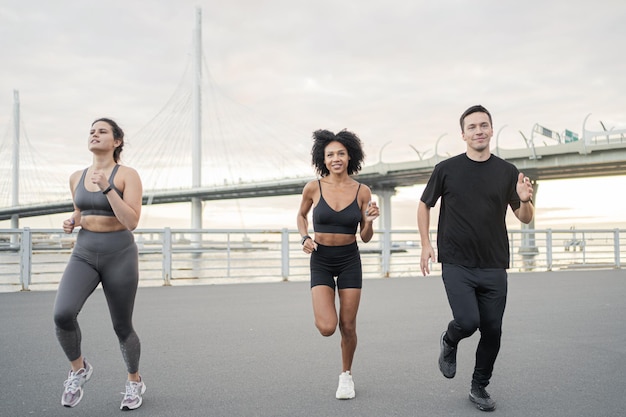 Ludzie przyjaciele sportowcy biegają po zdrowie i szczęście Mężczyzna i kobieta fitness na ulicy