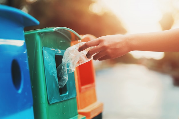 Ludzie ręki trzymającej śmieci butelki plastikowe wprowadzenie do kosza do czyszczenia