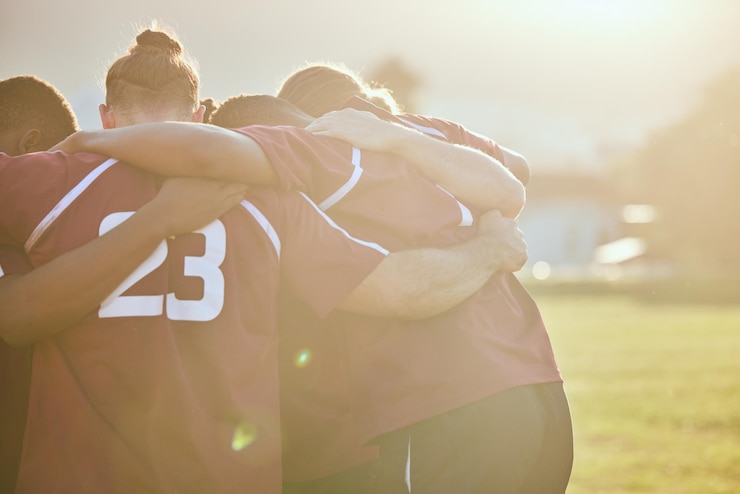 Zdjęcie ludzie rugby i skupiają się w motywacji do sportów zespołowych lub przygotowują się do meczu lub gry na boisku na świeżym powietrzu aktywni mężczyźni w kręgu lub uścisku grupowym we współpracy w pracy zespołowej lub zaufaniu scrumowi w zakresie sprawności fizycznej
