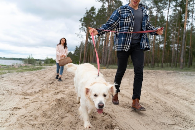 Ludzie spacerujący z psem na plaży z bliska