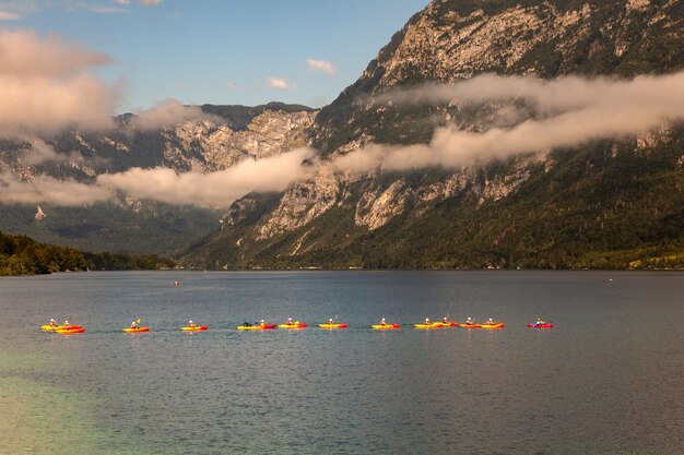 Ludzie spływa kajakiem po jeziorze Bohinj