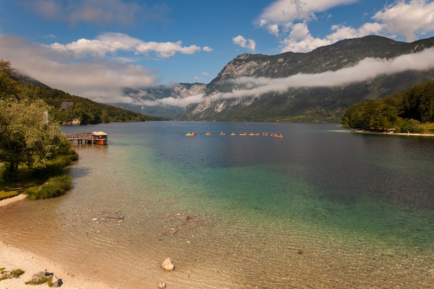 Ludzie spływa kajakiem po jeziorze Bohinj