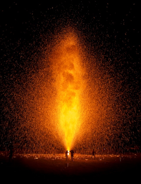Zdjęcie ludzie sylwetki w smugach fajerwerków na tle